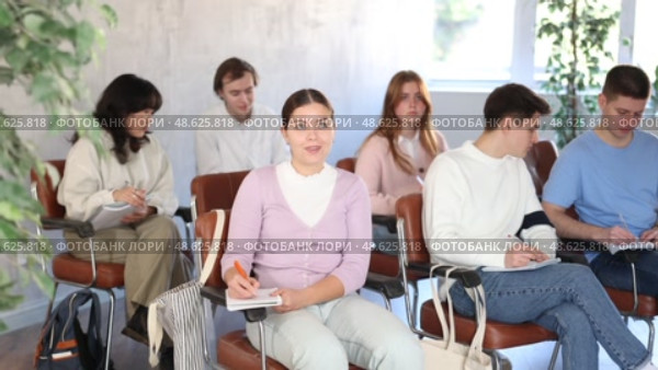 Group of concerned undergraduates listening to lecture and making notes attentively in auditorium. Стоковое видео, видеограф Яков Филимонов / Фотобанк Лори
