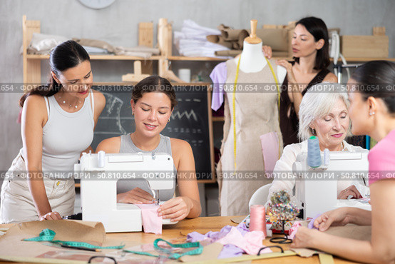 Group of happy attendees of dressmaking courses engaged in different activities. Стоковое фото, фотограф Яков Филимонов / Фотобанк Лори