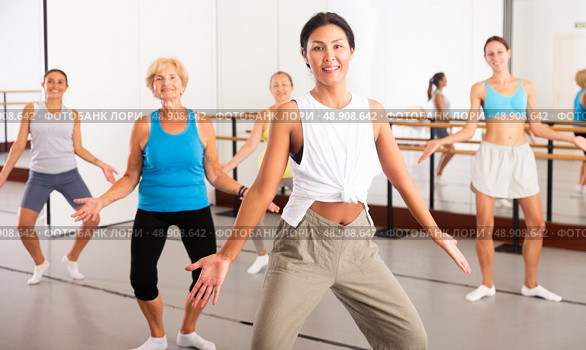 Group of happy women different ages practicing zumba in dance class. Стоковое фото, фотограф Яков Филимонов / Фотобанк Лори