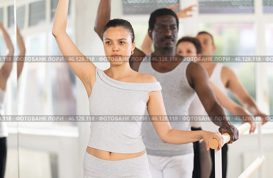 Group of men and women will learn to stand in third position during ballet rehearsal. Стоковое фото, фотограф Яков Филимонов / Фотобанк Лори