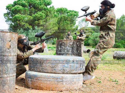 Group of people in full gear playing paintball on shooting range outdoor. Стоковое фото, фотограф Яков Филимонов / Фотобанк Лори