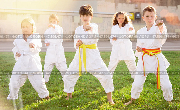 Group of preteen children practicing karate in summer park. Стоковое фото, фотограф Яков Филимонов / Фотобанк Лори