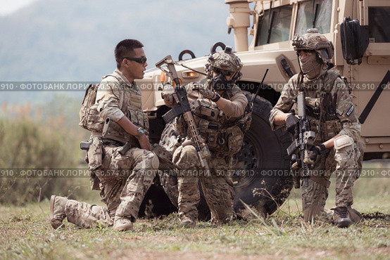 Group of soldiers in camouflage uniforms hold weapons in a jltv car, Plan and prepare for combat training. Стоковое фото, агентство Ingram Publishing / Фотобанк Лори