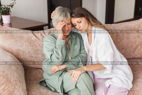 Grown up daughter soothe aged mother holds her hand feel empathy give her moral support, sad elderly woman at home. Стоковое фото, фотограф Гладских Татьяна / Фотобанк Лори