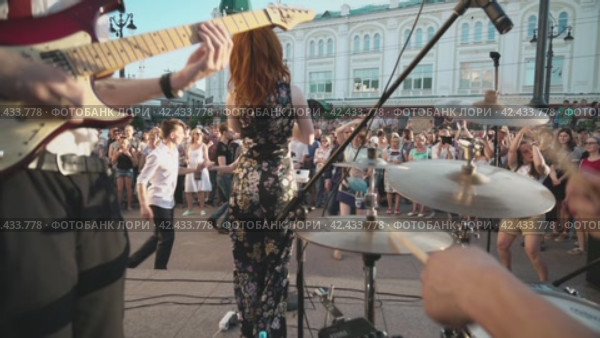 Группа музыкантов исполняет музыку на оживленной городской улице. Туристы и граждане наслаждаются и танцуют под фольклорную музыку. Group street musicians performing music in busy city street. Tourist and citizen people enjoy and dance to folk band play music. Omsk, Russia (2019 год). Редакционное видео, видеограф EStarodubov / Фотобанк Лори