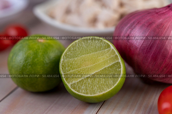 Half cut lemons and red onions placed on a wooden table. Selective focus. Стоковое фото, агентство Ingram Publishing / Фотобанк Лори