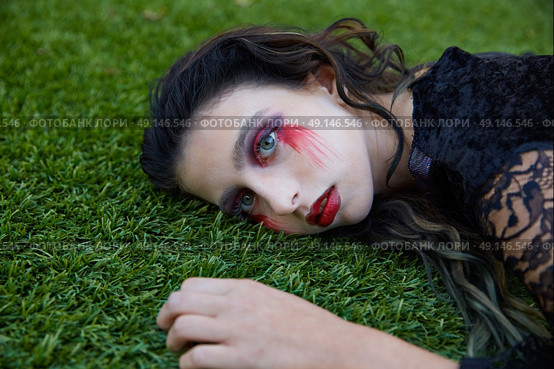 Halloween kid girl custome with bloody makeup on backyard turf. Стоковое фото, агентство Ingram Publishing / Фотобанк Лори