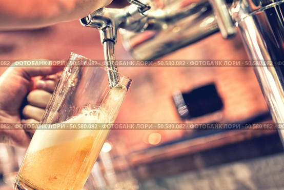 Hand of bartender pouring a large lager beer in tap. Стоковое фото, агентство Ingram Publishing / Фотобанк Лори