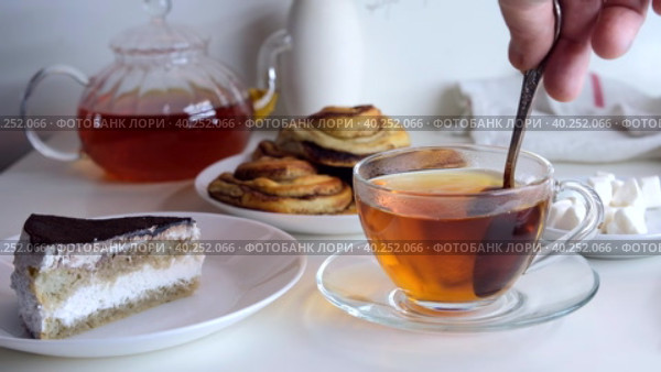 Hand stirs a teaspoon of sugar in a cup. Breakfast with cake. Стоковое видео, видеограф Ирина Толокновская / Фотобанк Лори