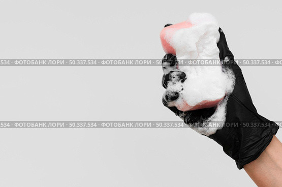 hand with glove holding sponge with foam copy pace. Стоковое фото, агентство Ingram Publishing / Фотобанк Лори