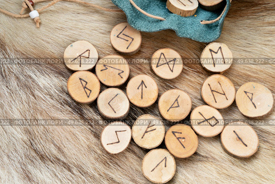 Handmade runes for fortunetelling in leather bag over wolf fur. Handmade runes for fortunetelling. Стоковое фото, агентство Ingram Publishing / Фотобанк Лори
