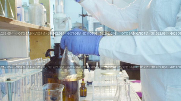 Hands of a scientist titrating solution. Стоковое видео, видеограф Chudakov_Ivan / Фотобанк Лори