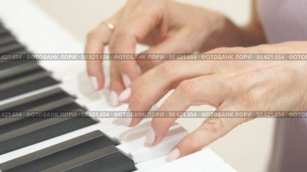 Hands Piano Keys Playing Music: Indoor close-up showing woman's hands playing a keyboard. Стоковое видео, видеограф svetograph / Фотобанк Лори