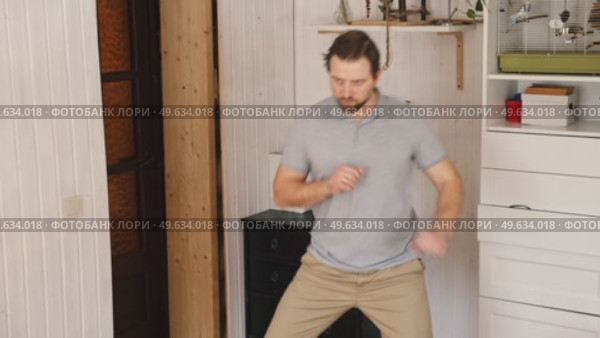 Handsome bearded man dance, have fun at home listens song, moves to music, feels overjoyed, celebrate good news, relish carefree life looks happy. Young adult male twirls, grooves. Brutal man dancer. Стоковое видео, видеограф Марина Демидюк / Фотобанк Лори