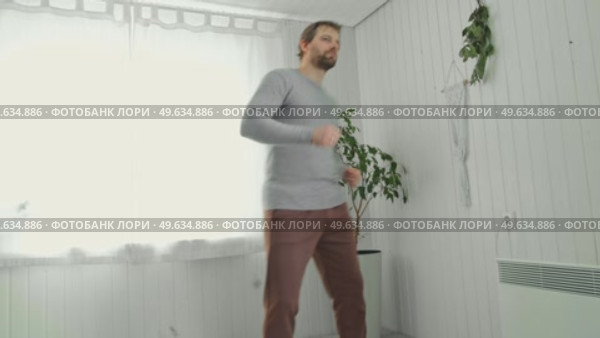 Handsome bearded man dance, have fun at home listens song, moves to music, feels overjoyed, celebrate good news, relish carefree life looks happy. Young adult male twirls, grooves. Brutal man dancer. Стоковое видео, видеограф Марина Демидюк / Фотобанк Лори