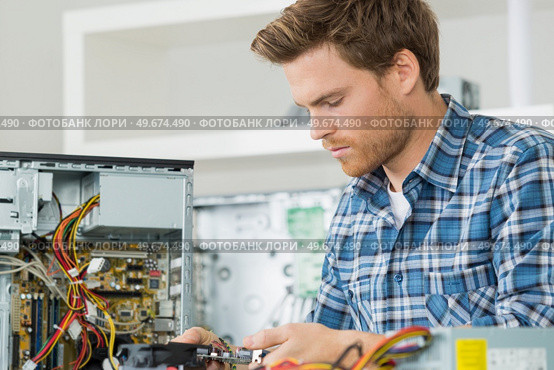 handsome computer engineer repairing a faulty pc. Стоковое фото, агентство Ingram Publishing / Фотобанк Лори