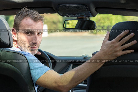 handsome man is driving in reverse. Стоковое фото, агентство Ingram Publishing / Фотобанк Лори