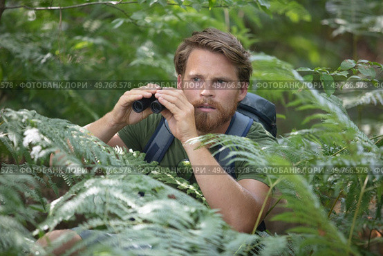 handsome scared and shocked traveler with binoculars. Стоковое фото, агентство Ingram Publishing / Фотобанк Лори