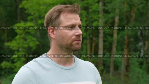 Handsome young man standing outdoors. Male thinking looking around feel happy, calm and serious. Green park background. Guy business employer, businessman manager inspired in nature. Diversity People. Стоковое видео, видеограф Марина Демидюк / Фотобанк Лори