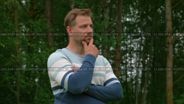 Handsome young man standing outdoors. Male thinking looking around feel happy, calm and serious. Green park background. Guy business employer, businessman manager inspired in nature. Diversity People. Стоковое видео, видеограф Марина Демидюк / Фотобанк Лори