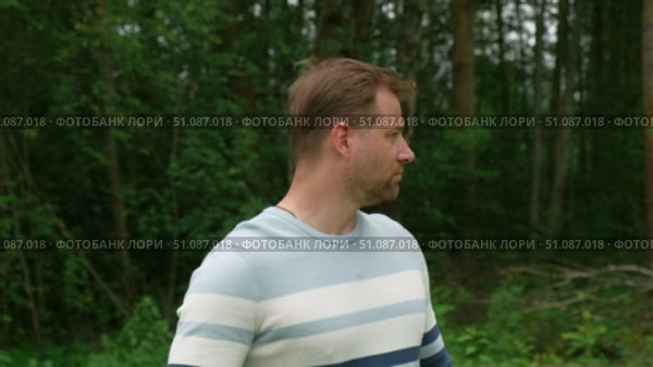 Handsome young man standing outdoors. Male thinking looking around feel happy, calm and serious. Green park background. Guy business employer, businessman manager inspired in nature. Diversity People. Стоковое видео, видеограф Марина Демидюк / Фотобанк Лори