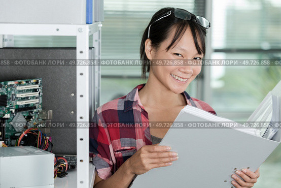 happy casual woman holding a folder. Стоковое фото, агентство Ingram Publishing / Фотобанк Лори
