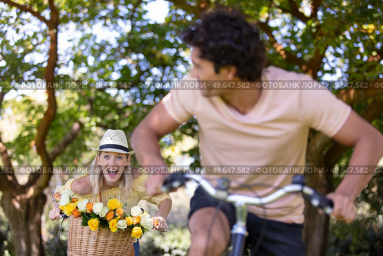 happy couple chasing on bike in the park. Стоковое фото, агентство Ingram Publishing / Фотобанк Лори