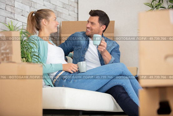 happy couple taking break unpacking on moving day. Стоковое фото, агентство Ingram Publishing / Фотобанк Лори