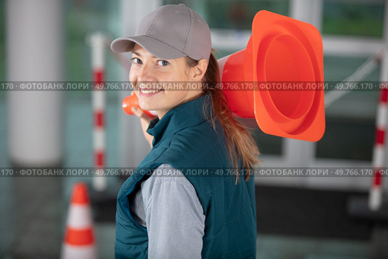 happy female builder holding traffic cone. Стоковое фото, агентство Ingram Publishing / Фотобанк Лори