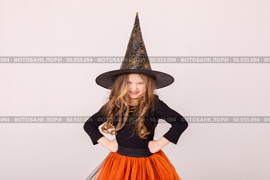 Happy funny child girl in witch costume on Halloween makes horror face and grimaces on white background. Halloween party girl. Happy Halloween Witch. High quality photo. Стоковое фото, фотограф Ирина Михайличенко / Фотобанк Лори