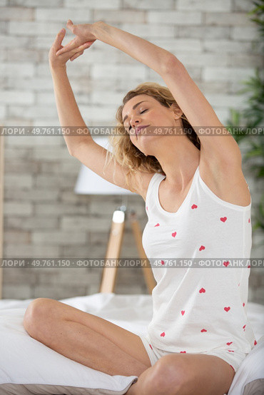 happy girl waking up stretching arms on the bed. Стоковое фото, агентство Ingram Publishing / Фотобанк Лори