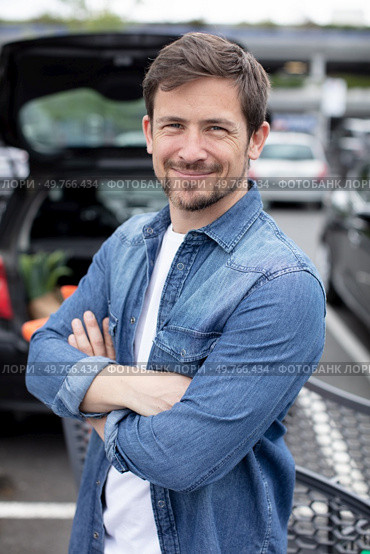 happy man in supermarket carpark with arms crossed. Стоковое фото, агентство Ingram Publishing / Фотобанк Лори