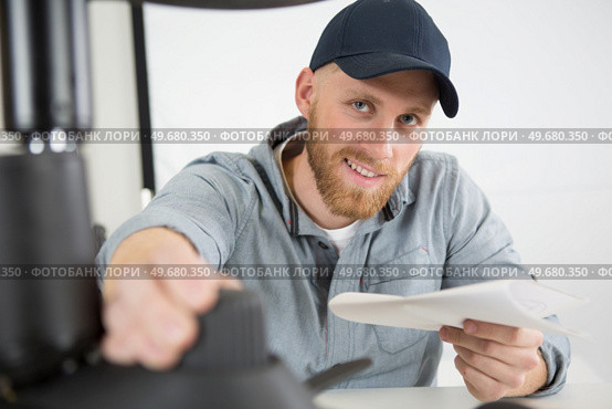 happy man screwing screws into furniture fittings. Стоковое фото, агентство Ingram Publishing / Фотобанк Лори