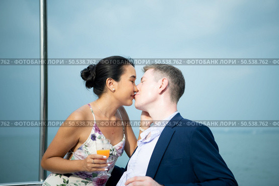 Happy moments of interracial couples on a yacht The couple had their honeymoon at one of Asia’s most beautiful seas. Стоковое фото, агентство Ingram Publishing / Фотобанк Лори