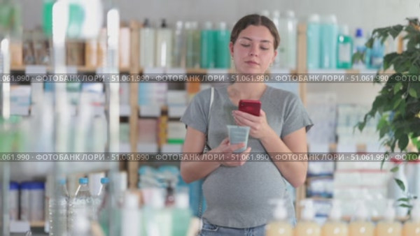 Happy pregnant woman customer holding, scan QR code on label and selecting cream or skin care product in modern drugstore. Стоковое видео, видеограф Яков Филимонов / Фотобанк Лори