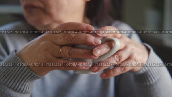 Happy senior woman having a coffee break and thinking at home. Face of an elderly lady feeling nostalgic while having tea during retirement. Elderly woman thinking, decision with wellness and calm. Стоковое видео, видеограф Марина Демидюк / Фотобанк Лори