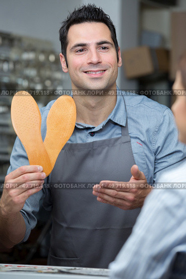 happy shoe worker holding shoes soles. Стоковое фото, агентство Ingram Publishing / Фотобанк Лори