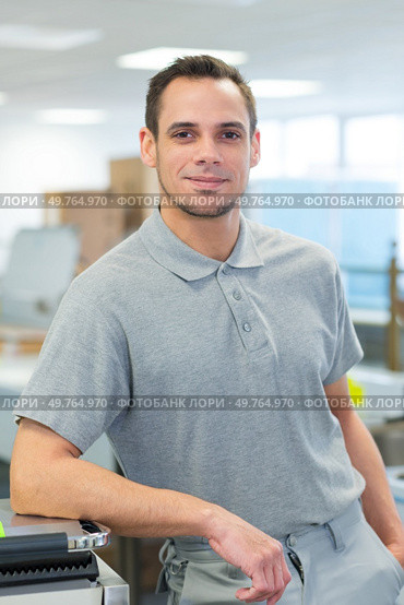 happy worker standing in factory. Стоковое фото, агентство Ingram Publishing / Фотобанк Лори