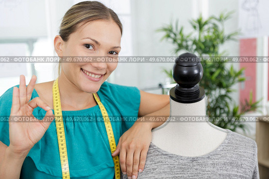 happy young dressmaker showing ok sign. Стоковое фото, агентство Ingram Publishing / Фотобанк Лори