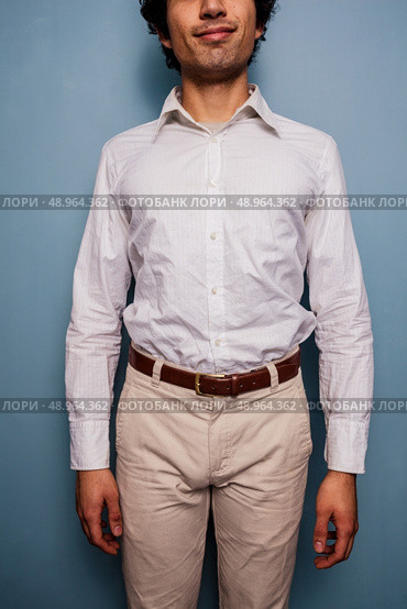 Happy young man against blue background. Стоковое фото, агентство Ingram Publishing / Фотобанк Лори