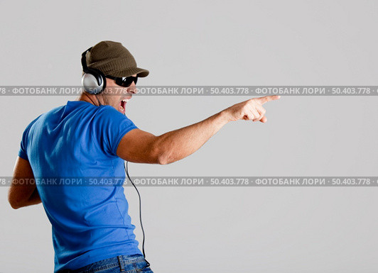 Happy young man with headphones listening music. Стоковое фото, агентство Ingram Publishing / Фотобанк Лори