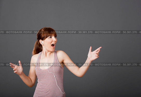 Happy young woman dancing and singing while listen music. Стоковое фото, агентство Ingram Publishing / Фотобанк Лори