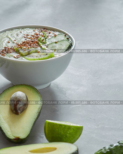 Healthy smoothies from lime, avocado, cucumber, and kiwi with flax seeds in a plate on a gray concrete background with copy space.. Healthy Vegetarian Food. In a white plate smoothies of cucumber and avocado with kiwi and flax seeds on a gray concrete background. Стоковое фото, агентство Ingram Publishing / Фотобанк Лори