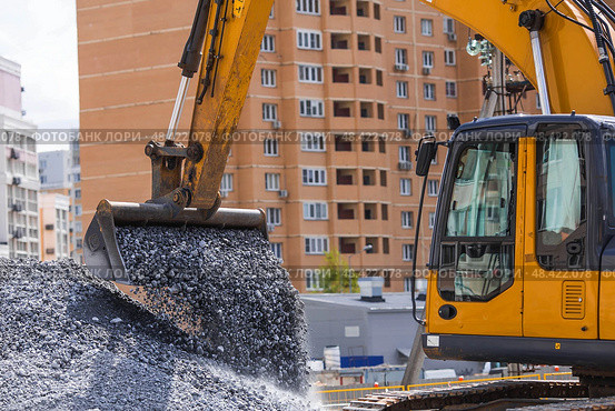 Heavy machinery for construction and landscaping. An excavator on a construction site in close-up. An excavator loads crushed stone into a bucket for construction. Стоковое фото, фотограф Photojuli / Фотобанк Лори