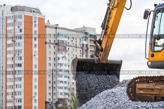 Heavy machinery for construction and landscaping. An excavator on a construction site in close-up. An excavator loads crushed stone into a bucket for construction. Стоковое фото, фотограф Photojuli / Фотобанк Лори