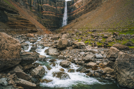 Hengifoss waterfall in East Iceland. Hengifoss is the third highest waterfall in Iceland and is surrounded by basaltic strata with red layers of clay between the basaltic layers (2020 год). Стоковое фото, фотограф Igor Tichonow / Фотобанк Лори