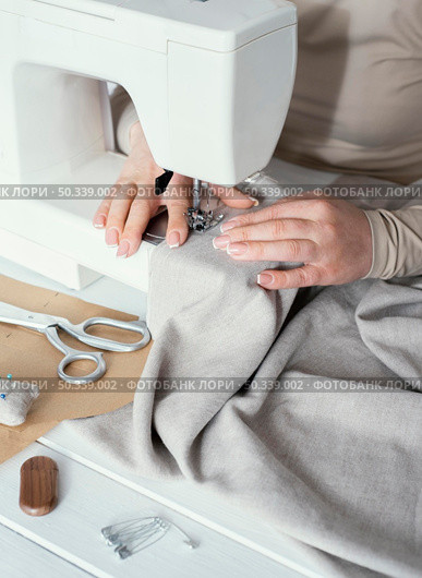 high angle seamstress using sewing machine. Стоковое фото, агентство Ingram Publishing / Фотобанк Лори