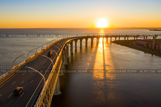 High-speed toll road, highway bypassing the city center St. Petersburg, the central section of the western high-speed section. A beautiful sunset over the Gulf of Finland. Стоковое фото, фотограф Mikhail Starodubov / Фотобанк Лори