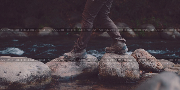 Hiking man with trekking boots on the trail.backpack.Hikers hiking in forest. Стоковое фото, агентство Ingram Publishing / Фотобанк Лори