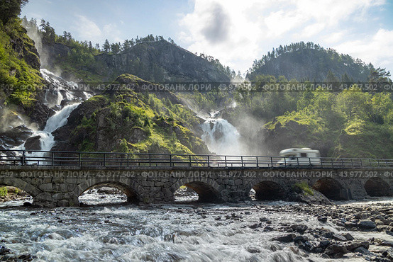 Holiday trip in motorhome, Caravan car Vacation. RV traveling on the road Latefossen Waterfall Odda Norway. Latefoss is a powerful, twin waterfall. Стоковое фото, фотограф Андрей Армягов / Фотобанк Лори